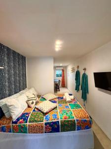 a bedroom with a bed with a colorful quilt at Suíte 3 - Village Capixaba in Gravatá +1 photo