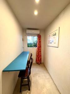 a small room with a blue table and a chair at Suíte 3 - Village Capixaba in Gravatá