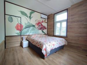 a bedroom with a bed and a large painting on the wall at Boerderij Buitink in Kotten