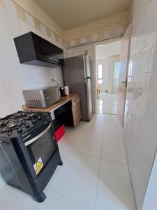 a kitchen with a stove and a refrigerator at Comfortable apartment in Aracaju in Aracaju
