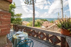 a table and chairs on a balcony with a view at The Clock Tower View Loft in Montecatini Alto