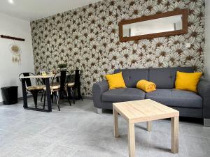 a living room with a blue couch and a table at La Pause Bain & Nature in Incheville