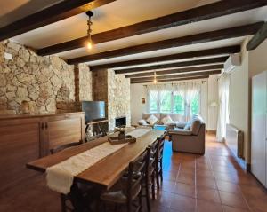 a kitchen and living room with a large wooden table at La Guijarroseña , Rio Madera in Segura de la Sierra