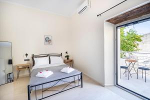 a bedroom with a bed and a large window at Nikos StoneHouse in Prinés