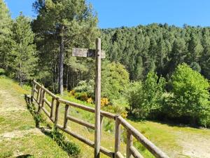 a wooden sign on a hill next to a fence at La Guijarroseña , Rio Madera in Segura de la Sierra