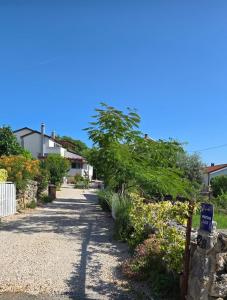 a walkway in a yard with trees and flowers at Apartman Luce in Krk