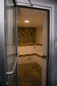 a bathroom with a walk in shower next to a glass door at Ramada by Wyndham Medicine Hat in Medicine Hat