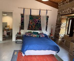 una camera da letto con un grande letto con lenzuola e cuscini blu di Casa Vella do Nanín a Faramontaos