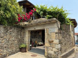un edificio in pietra con fiori sopra di Casa Vella do Nanín a Faramontaos Altre 11 foto