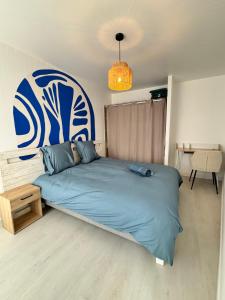 a bedroom with a large bed with a blue comforter at Escapade Santorini Epinal in Épinal