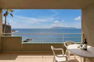 balkon ze stołem i widokiem na ocean w obiekcie Costa Isora Frontline & Pool By Paramount Holidays w mieście Puerto de Santiago