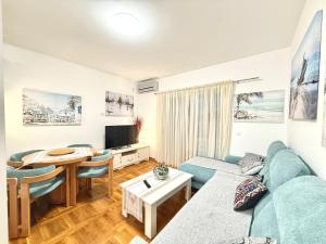 a living room with a blue couch and a table at Varja 2 Apartment in Sveti Stefan