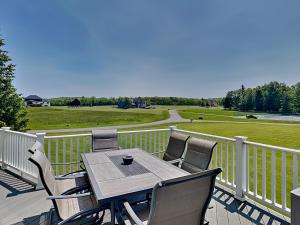 a table and chairs on a deck with a view of a field at Dacha Verde in Swanton