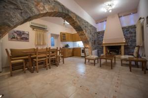 a kitchen and dining room with a stone wall at Casa Betini Traditional Maisonette in Káto Eloúnda