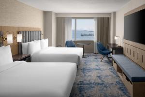a hotel room with two beds and a television at Hyatt Regency Jersey City on the Hudson in Jersey City +84 photos