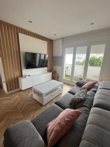 a living room with a couch and a flat screen tv at Apartamento Recién reformado en EL TOYO in Retamar