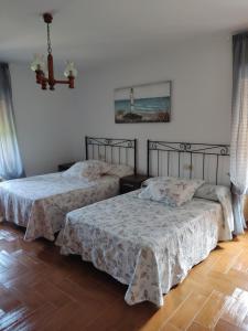 deux lits dans une chambre aux murs blancs et au parquet dans l'établissement Casa Carreta, à Serres
