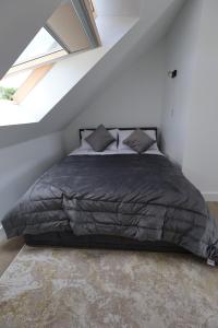 a bedroom with a black bed in a attic at NEW-BUILD Luxury House for Families and Contractors, NamisSuites Serviced Apartment - Farnborough in Farnborough
