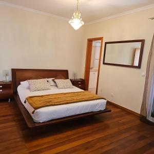 una camera da letto con un letto e un lampadario di Jose & Idalina House a Funchal