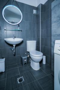 a bathroom with a toilet and a sink and a mirror at NOMA Urban Stay in Thessaloniki
