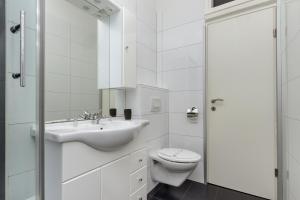 La salle de bains blanche est pourvue d'un lavabo et de toilettes. dans l'établissement Centar Split Apartments Manuš, à Split