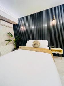 una camera con un letto bianco e una parete nera di zebra otel buca a Buca