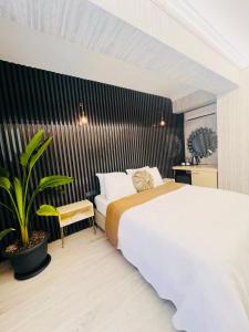una camera con un grande letto e una pianta di zebra otel buca a Buca