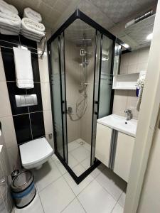 un bagno con doccia, WC e lavandino di zebra otel buca a Buca