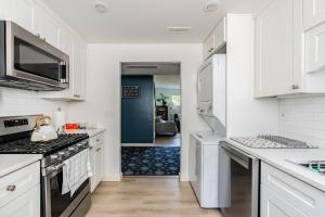 a kitchen with white cabinets and a stove top oven at 1400sf Cozy Retreat with Sound View, Garden & Privacy in Federal Way