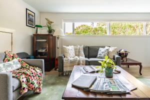 a living room with a couch and a table at 1400sf Cozy Retreat with Sound View, Garden & Privacy in Federal Way