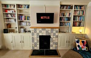 a living room with a fireplace and book shelves at Prospect Cottage in Hythe
