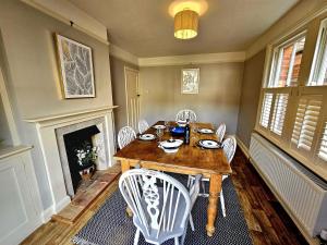 a dining room with a table and chairs and a fireplace at Prospect Cottage in Hythe +12 photos