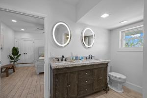 a bathroom with two sinks and a toilet and mirrors at Shell Hill house Waterfront, kayaks, grill, pier in Sealevel +72 photos