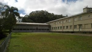 a large building with a grass field in front of it at Hotel Murialdo in Caxias do Sul +16 photos