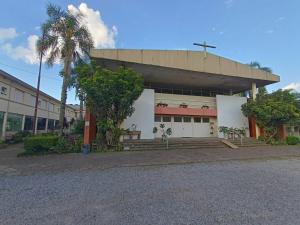 a building with a palm tree in front of it at Hotel Murialdo in Caxias do Sul