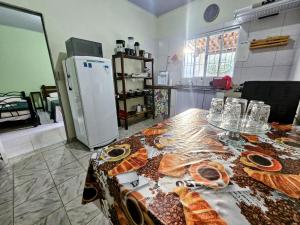 a kitchen with a table with bread and a refrigerator at Casa do Bueno in Teresina de Goias +5 photos