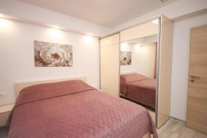 a bedroom with a bed and a mirror at House Konavle in Gruda