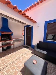 a living room with a couch and a fireplace at Casa do Pipo in Almograve