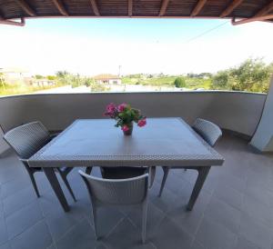 a table with a vase of flowers on a balcony at Villa VVG in Koxhas