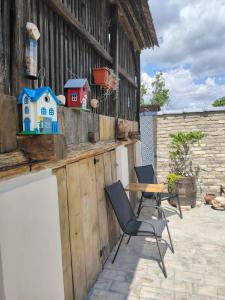 a patio with two chairs and a table and a fence at Apartman Katarina Bački Monoštor in Bački Monoštor +97 photos