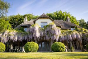 a house covered in wreaths of purple flowers at H Oxencombe Farm House in Newton Abbot