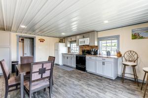 a kitchen with white cabinets and a table and chairs at Sunrise Landing: Waterfront Cottage in Avenue! in Avenue +20 photos