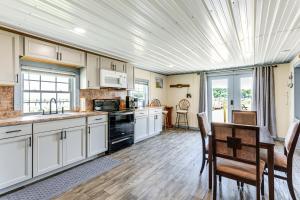 a kitchen with white cabinets and a table and chairs at Sunrise Landing: Waterfront Cottage in Avenue! in Avenue