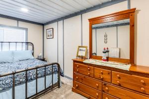 a bedroom with a bed and a dresser with a mirror at Sunrise Landing: Waterfront Cottage in Avenue! in Avenue