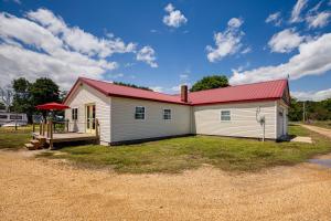 a white house with a red roof and a yard at Sunrise Landing: Waterfront Cottage in Avenue! in Avenue
