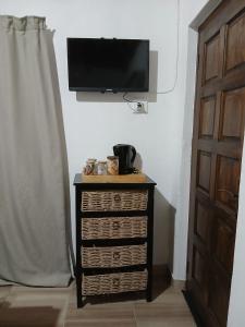 a dresser with a television on a wall next to a door at Aero Ensuites- OR Tambo in Kempton Park