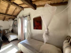 a bedroom with two beds and a net on the wall at Logis de la Vau - Private pool - Quiet in Saint-Benoist-sur-Mer +32 photos