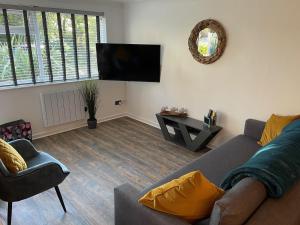 a living room with a couch and a tv at 51 Fernhill Heights in Bridport