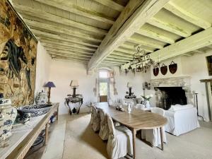 a dining room with a table and a fireplace at Logis de la Vau - Private pool - Quiet in Saint-Benoist-sur-Mer