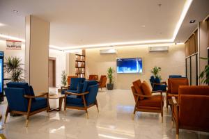 a waiting room with blue chairs and a tv at الان للشقق المخدومة in Hail +21 photos